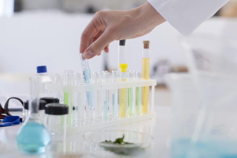 Hand holding a test tube with chemical solution in a laboratory setting
